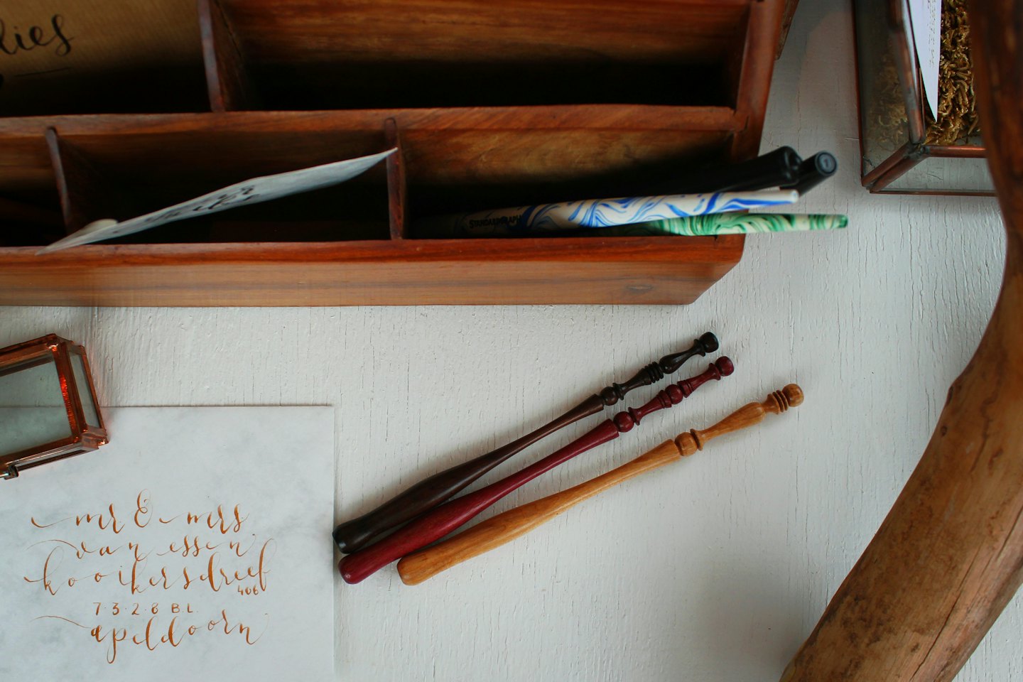 Penna per calligrafia e busta indirizzata su una scrivania.