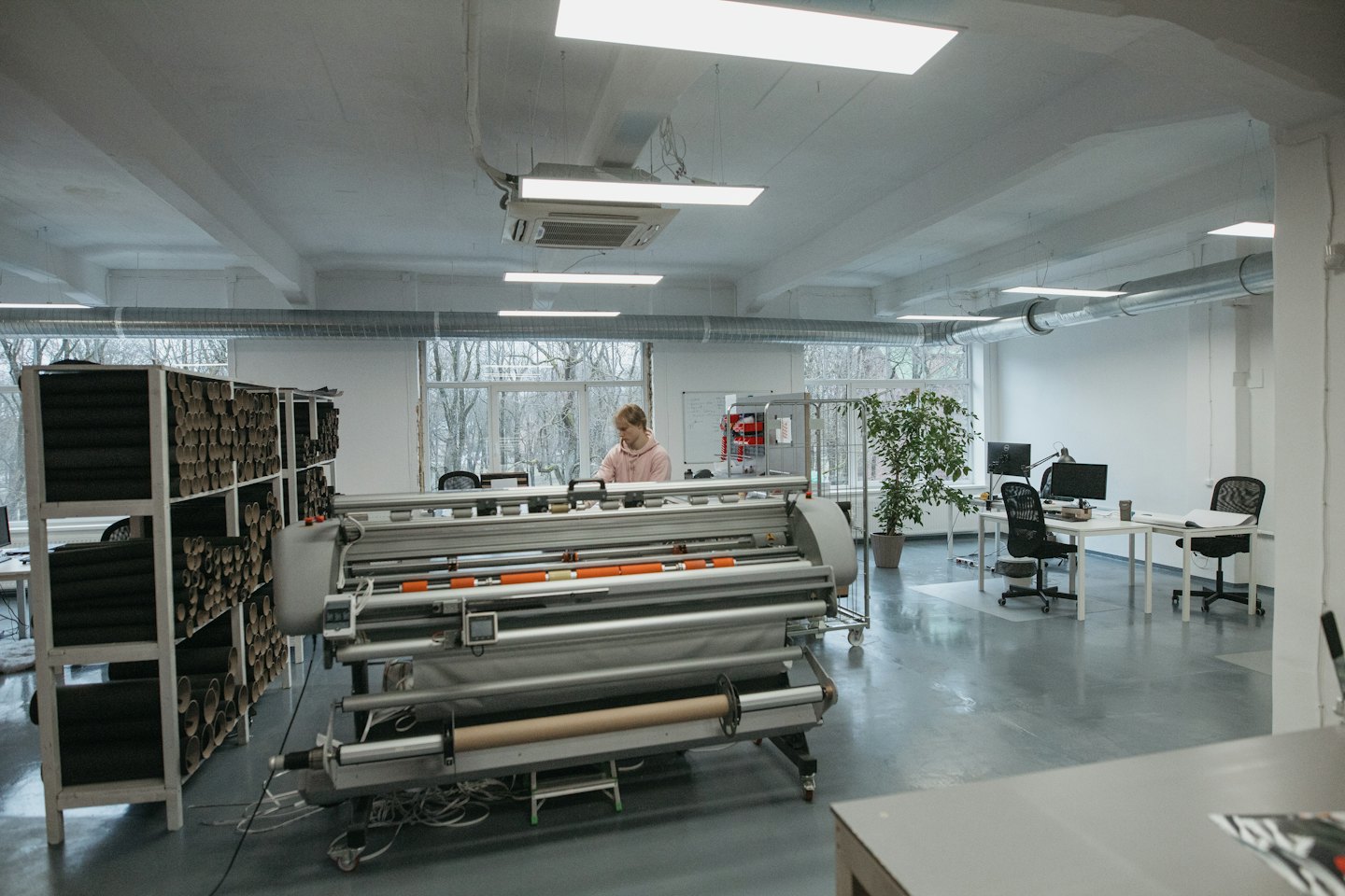 Persona che utilizza una stampante industriale di grande formato in un'officina.