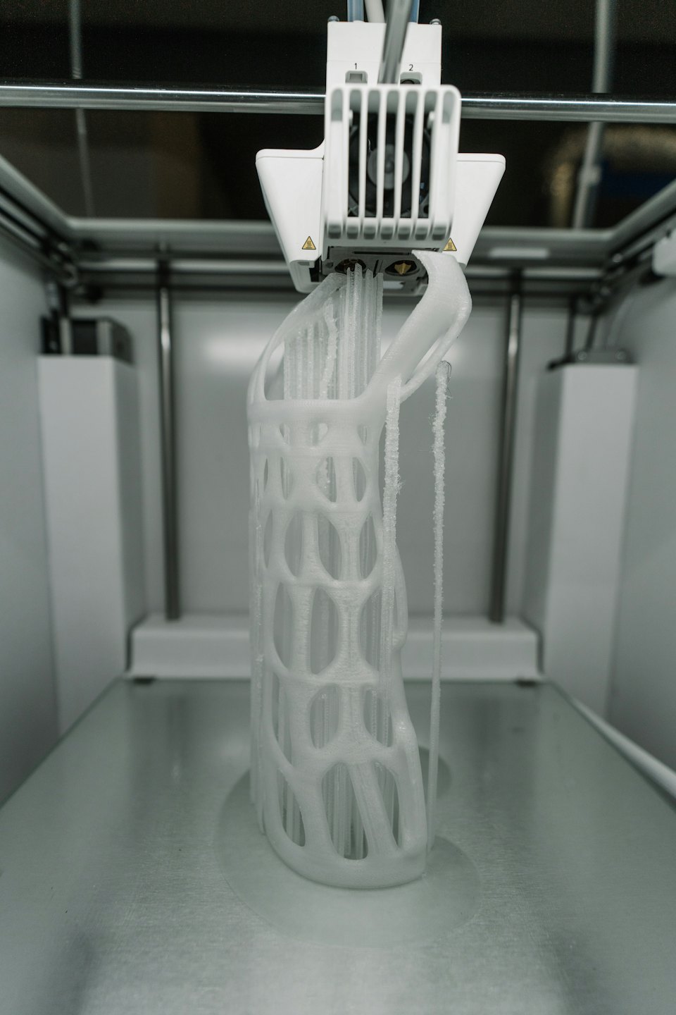 Stampante 3D che crea un oggetto bianco a griglia dettagliato.