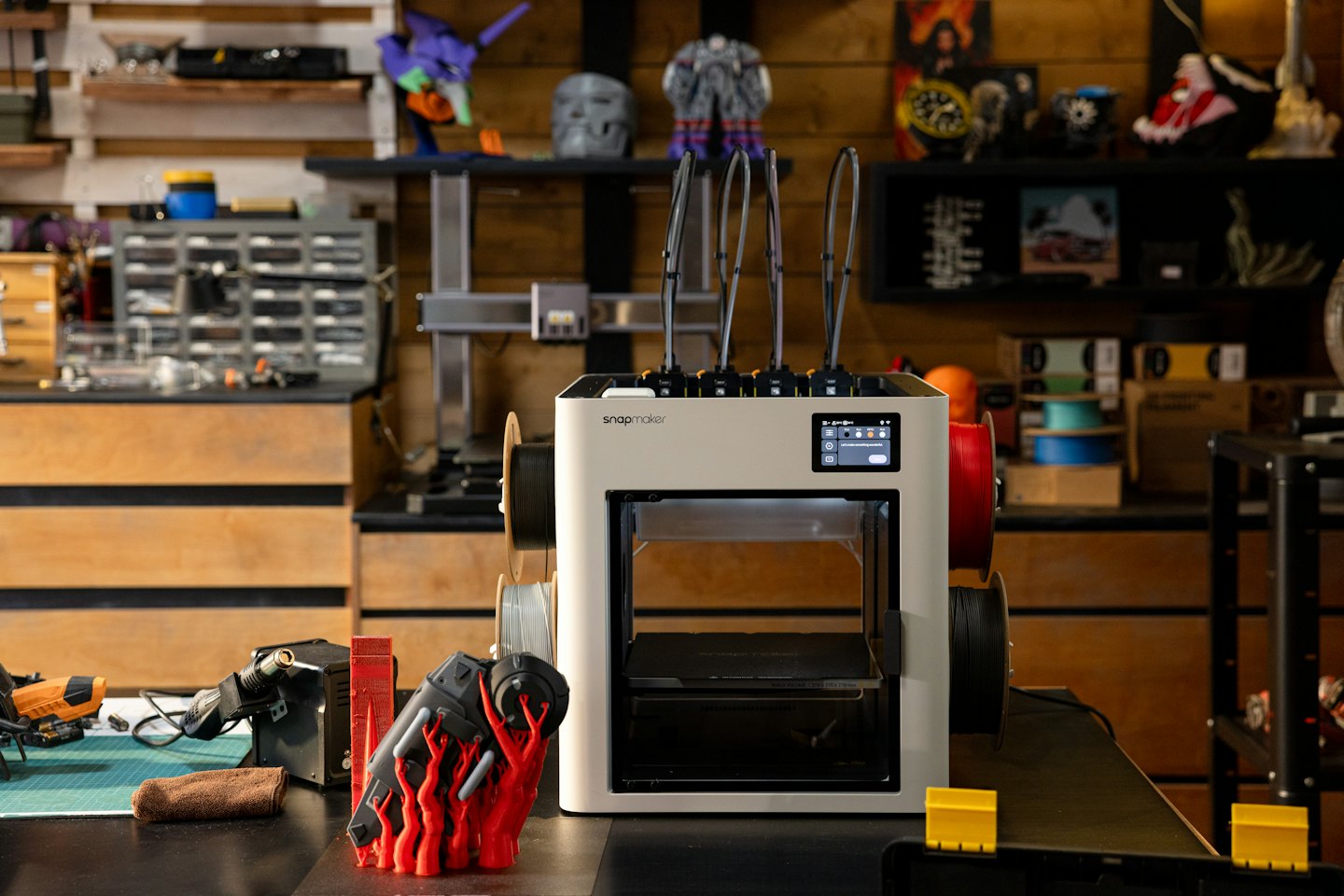 Stampante 3D Snapmaker su un banco da lavoro con attrezzi e forniture.